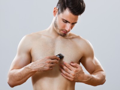 Mann rasiert sich seine Brust